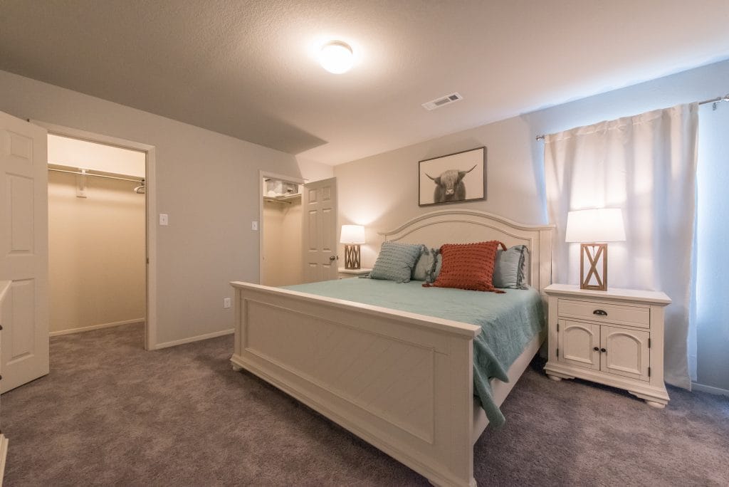 Cozy bedroom with plush carpet, queen bed, stylish decor, ample closet space, and soft lighting for a peaceful stay | Dream TDY