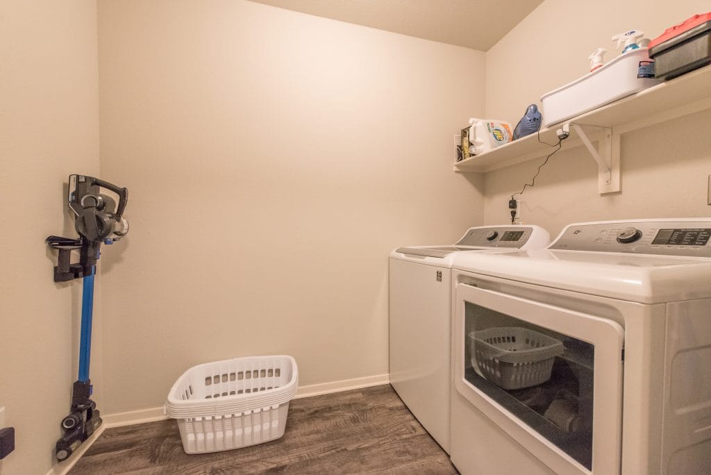 Ample laundry space with modern washer/dryer, practical shelving, and cleanliness ensures a convenient stay | Dream TDY