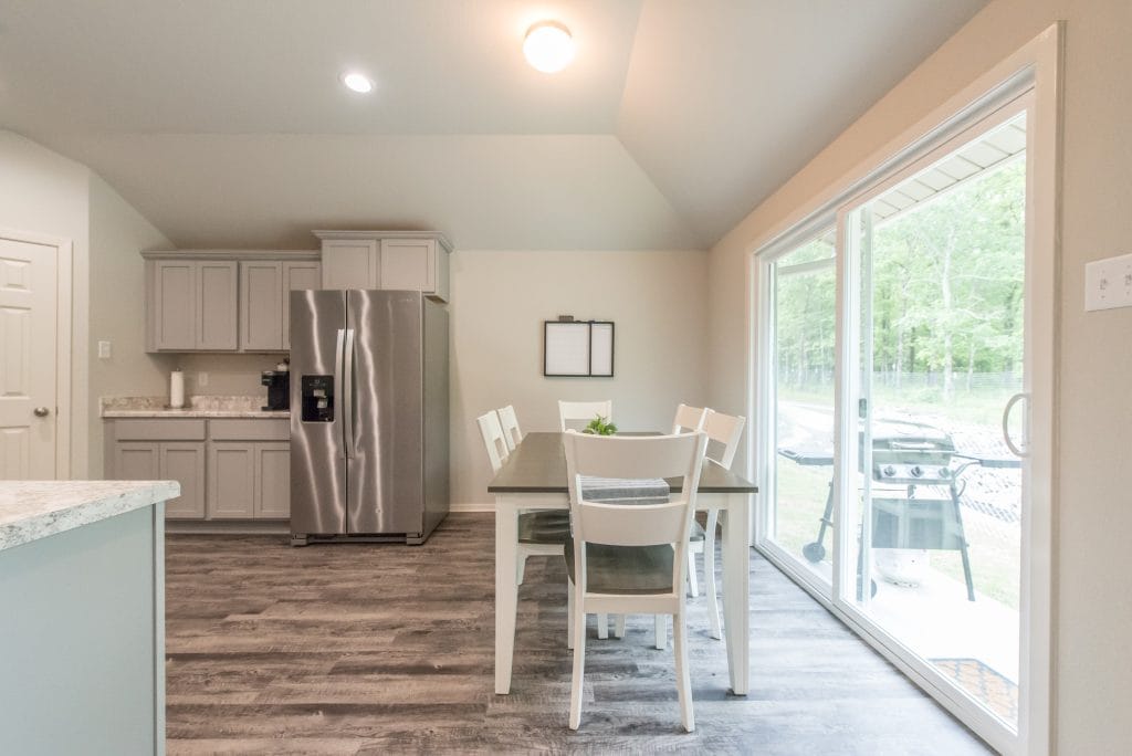 Modern kitchen and cozy dining area with stainless steel appliances, bright windows, and outdoor space for relaxation | Dream TDY