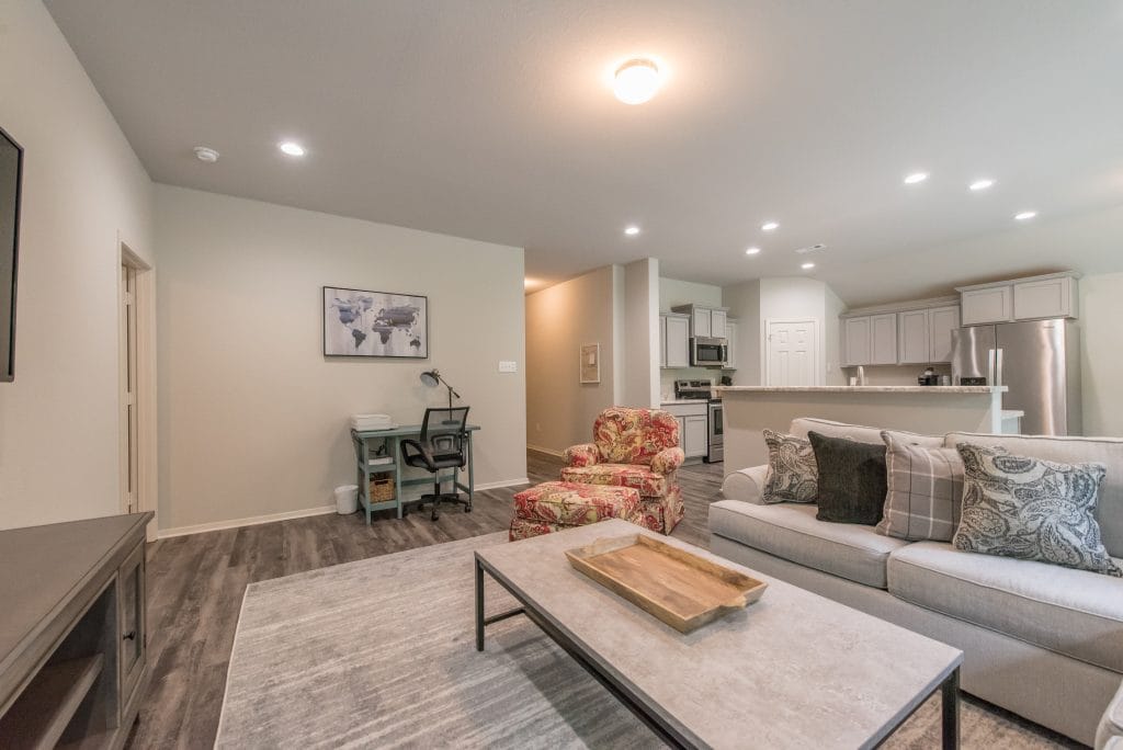 Bright and inviting living space with cozy furniture, dedicated workspace, modern kitchen appliances, and sleek flooring | Dream TDY