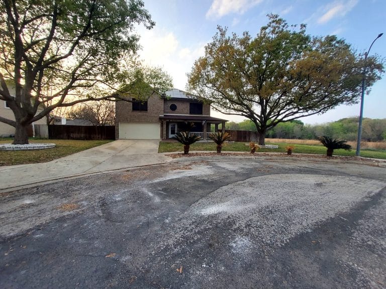 Spacious exterior with lush landscaping, inviting porch, and driveway access for easy parking | Dream TDY