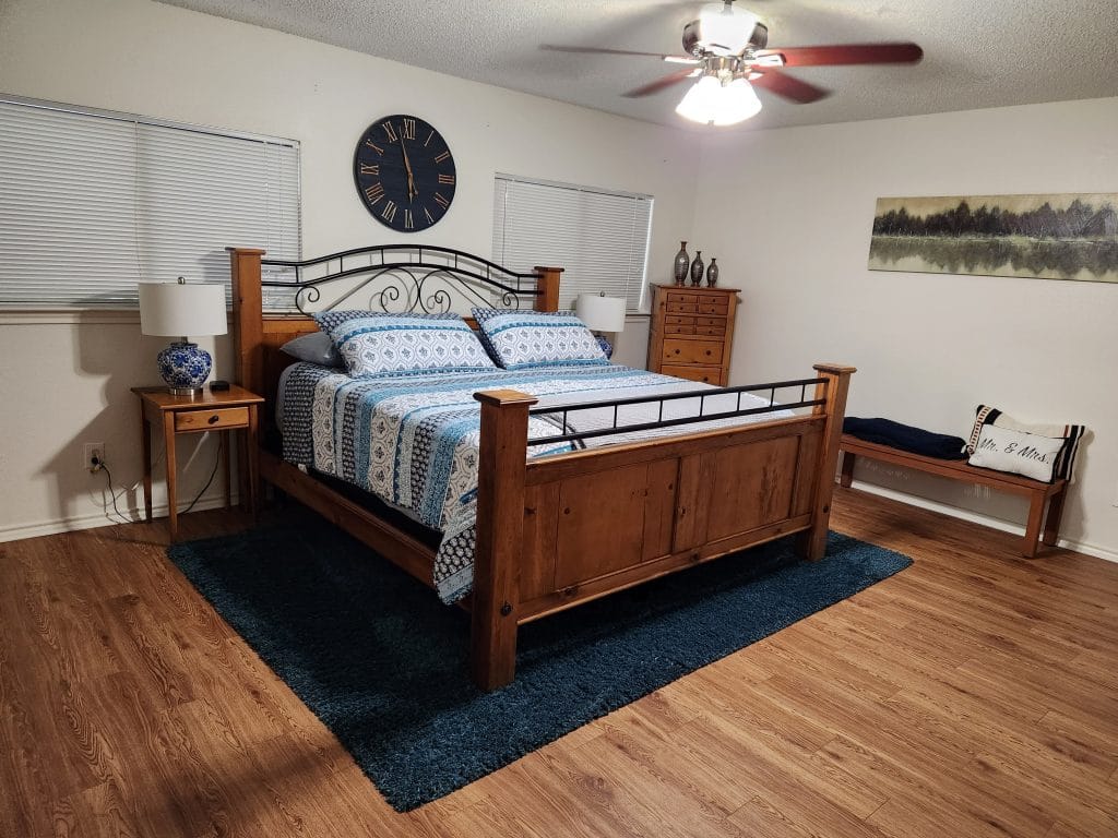 Spacious bedroom featuring cozy wood furniture, modern decor, and a dedicated workspace for comfort and productivity | Dream TDY