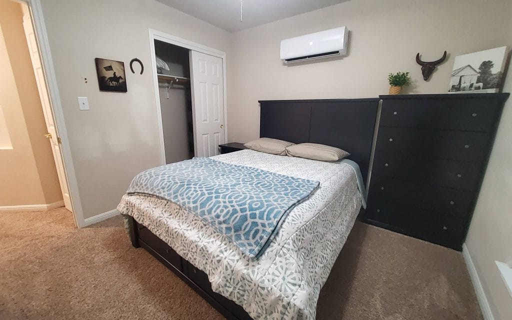 Cozy bedroom featuring a queen bed, ample storage, modern air conditioning, and a warm atmosphere for relaxation | Dream TDY