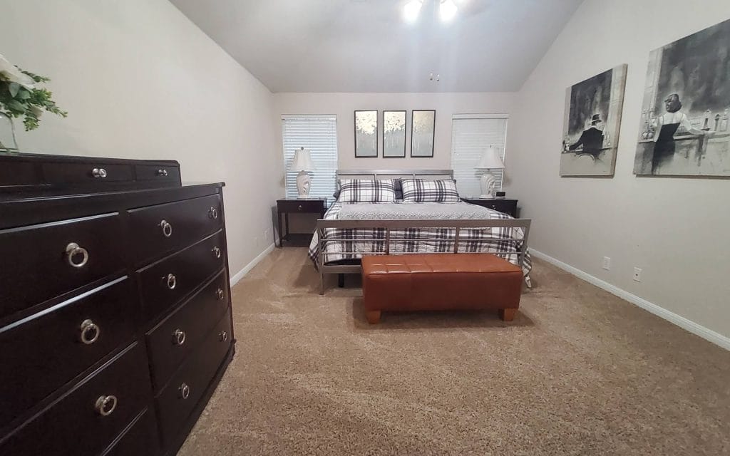Spacious bedroom features modern decor, king-size bed, cozy seating, and ample natural light | Dream TDY