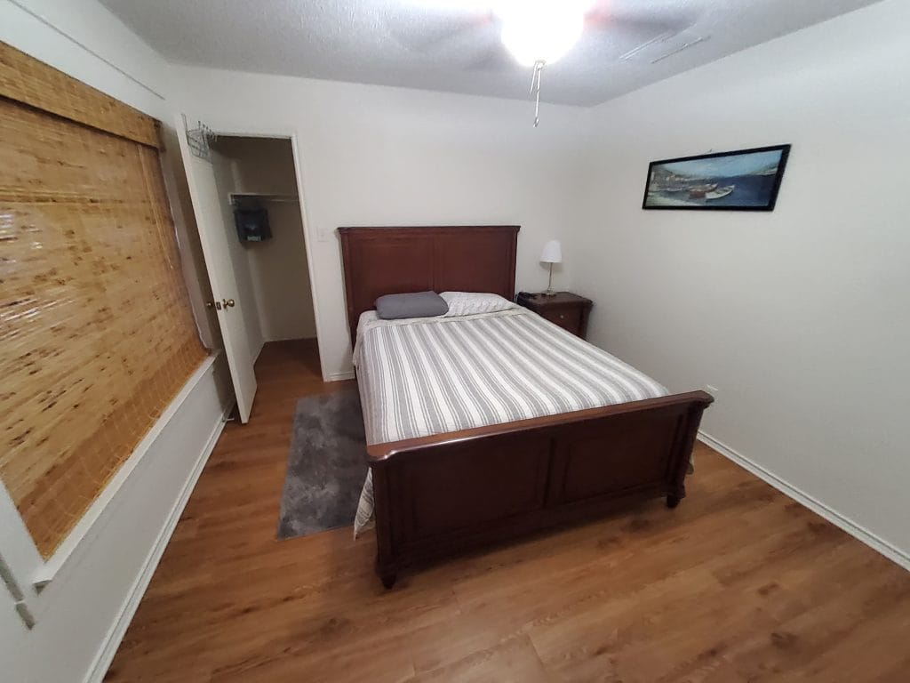 Cozy bedroom with warm wood accents, clean linens, and ample storage space. Ideal for a restful stay | Dream TDY