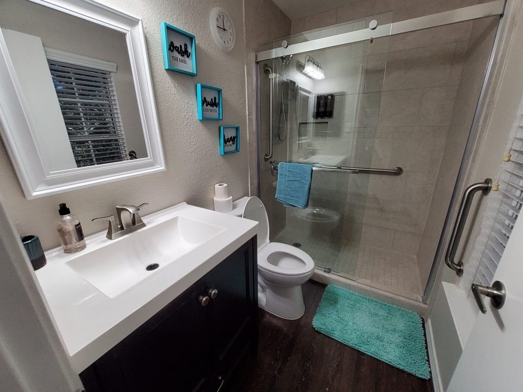 Modern bathroom featuring a sleek vanity, glass shower, and vibrant decor. Impeccably clean with essential toiletries available | Dream TDY