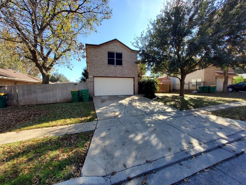 Charming exterior with ample parking, large yard, and trees offering shade. Perfect for a relaxing TDY experience | Dream TDY