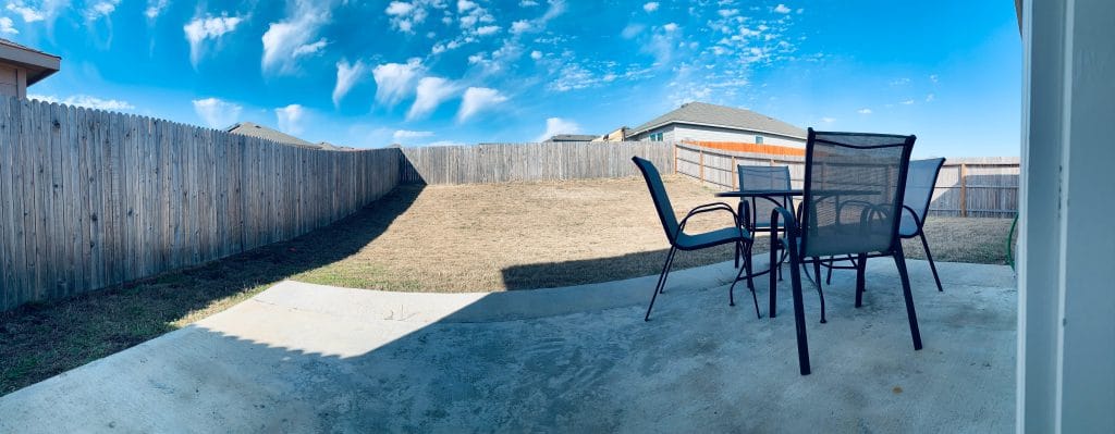 Spacious outdoor patio with seating, perfect for relaxation. Enjoy your private backyard under a clear blue sky | Dream TDY