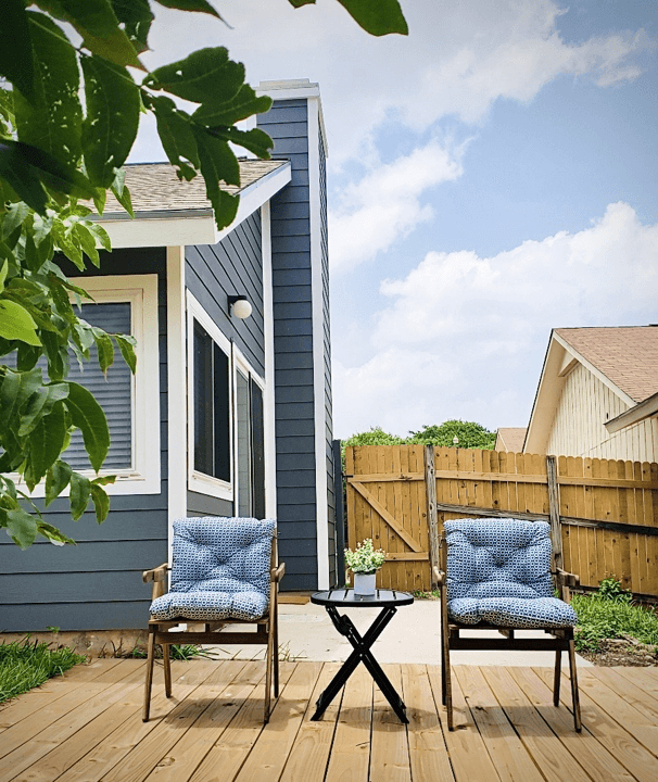 Inviting outdoor space with cozy chairs and a small table, perfect for relaxation. Clean and welcoming atmosphere | Dream TDY