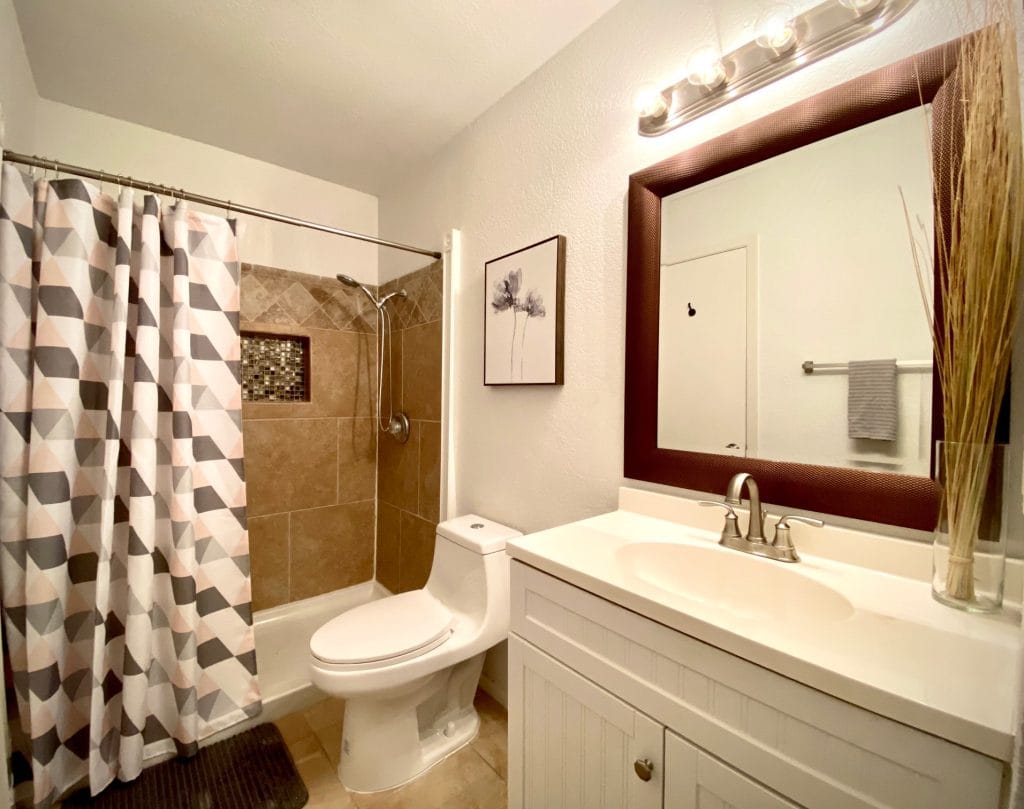 Modern bathroom featuring stylish tiled shower, sleek vanity, and clean decor. Perfect for a refreshing stay | Dream TDY