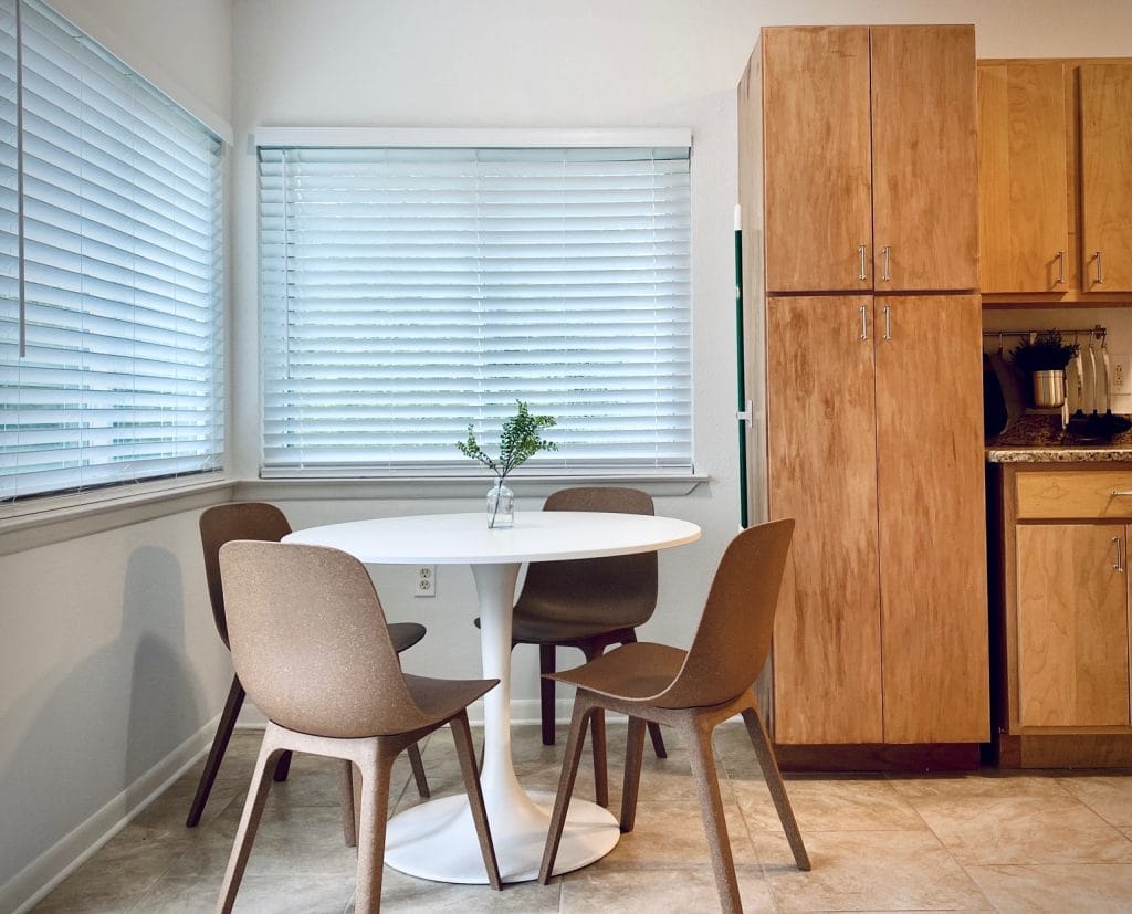 Bright dining area with modern round table and four stylish chairs. Clean, spacious feel with ample natural light. | Dream TDY