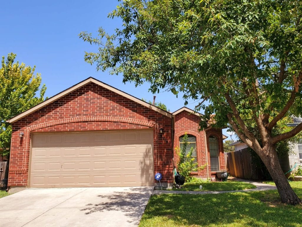 Charming brick exterior with a spacious driveway and lush yard, ideal for relaxation and outdoor gatherings | Dream TDY