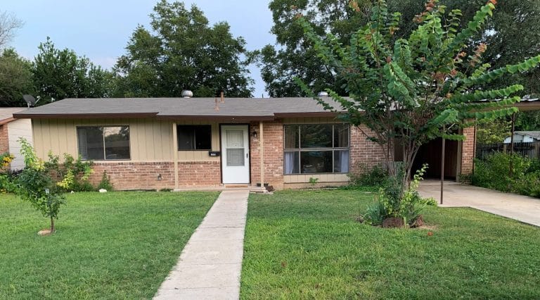 Charming brick exterior with lush green lawn, ample outdoor space, and convenient carport perfect for your military stay | Dream TDY