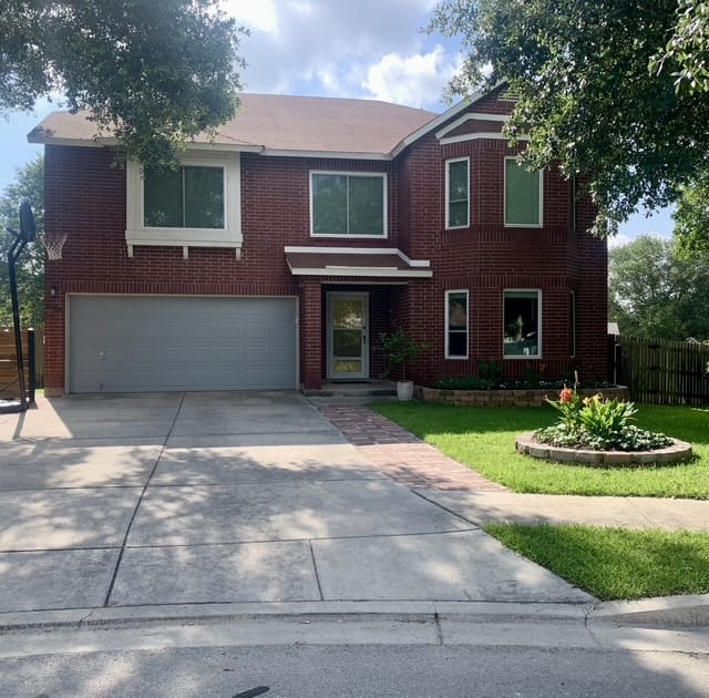 Charming red brick home with spacious yard, flower beds, ample parking, and easy outdoor access | Dream TDY