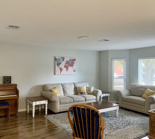 Bright and inviting living area with modern furniture, dedicated workspace, and large windows for natural light | Dream TDY