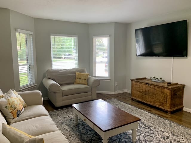 Inviting living area with cozy seating, natural light, modern TV, and elegant decor, perfect for relaxation after duties | Dream TDY