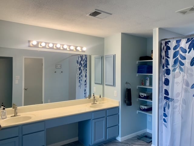 Bright, spacious bathroom with modern fixtures, dual sinks, and ample storage. Clean design ensures comfort and relaxation | Dream TDY