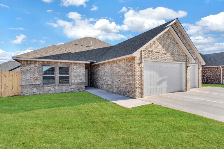 Inviting brick exterior with well-maintained lawn, two-car garage, and serene outdoor space perfect for relaxation | Dream TDY