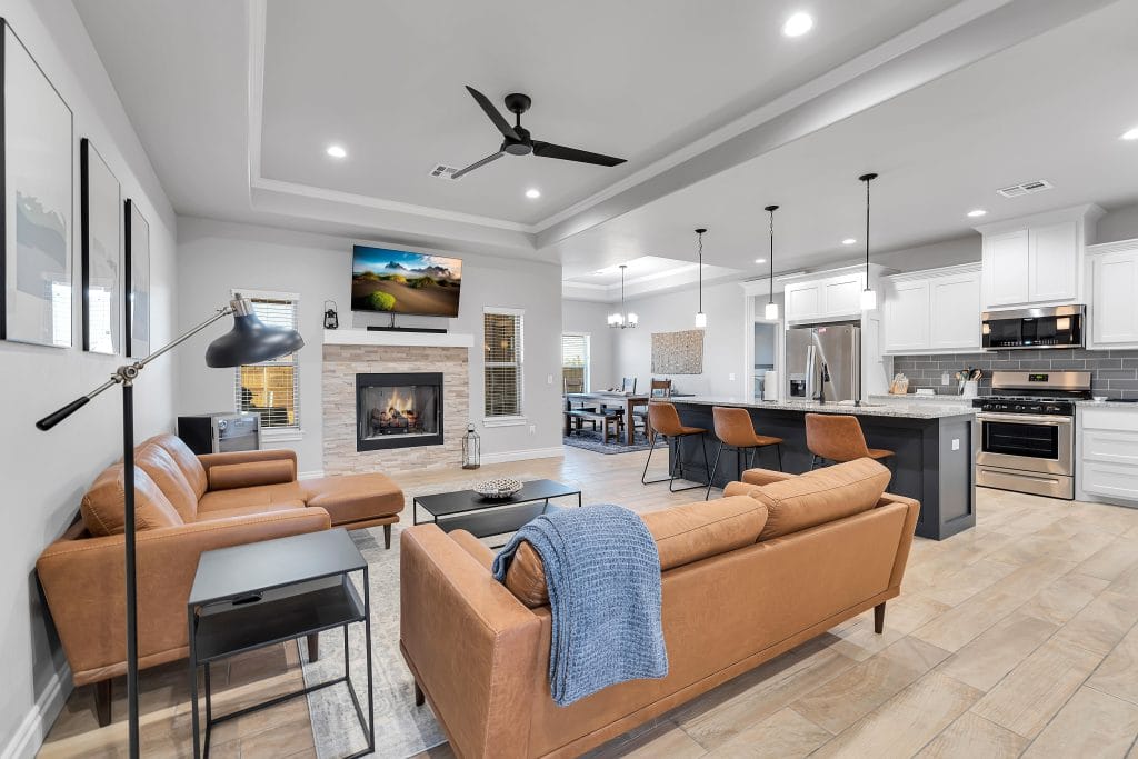 Stylish living space featuring modern leather furniture, cozy fireplace, dedicated workspace, and a fully equipped kitchen | Dream TDY