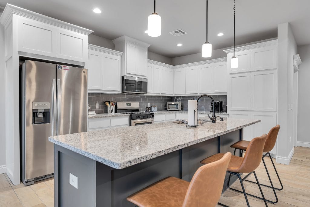 Modern kitchen featuring sleek stainless appliances, a spacious granite island, stylish bar seating, and ample storage | Dream TDY