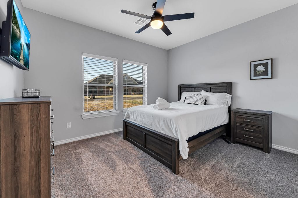 Comfortable, well-lit bedroom featuring a spacious layout, modern furnishings, and a cozy atmosphere. Perfect for short-term stays!