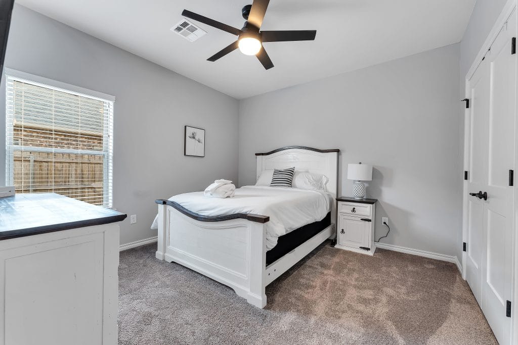 Cozy bedroom with modern decor, plush carpeting, stylish bed, workspace, and ample natural light for relaxation and productivity | Dream TDY 