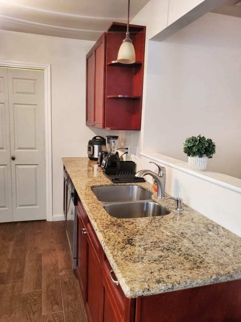 Modern kitchen with sleek granite countertops, stainless appliances, and a dedicated workspace for convenience | Dream TDY