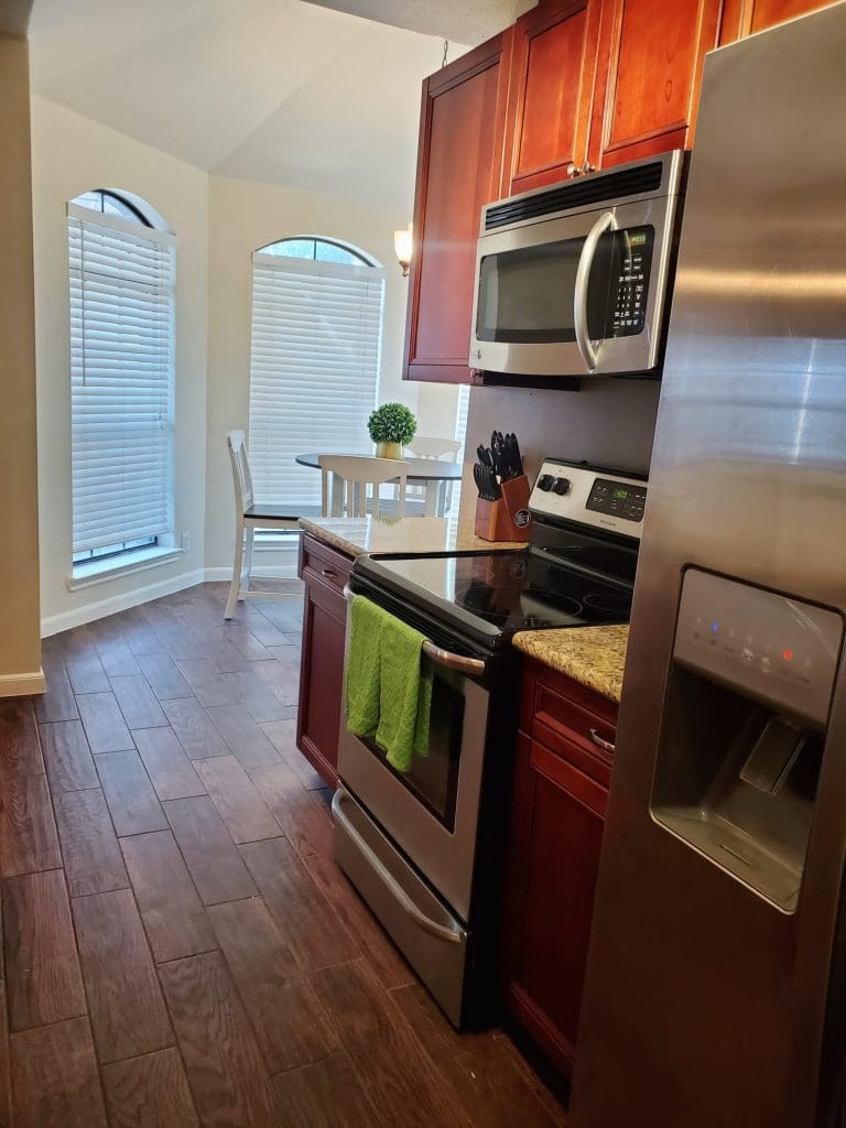 Gleaming kitchen with modern appliances, granite countertops, and a cozy dining nook, perfect for meal prep and relaxation | Dream TDY