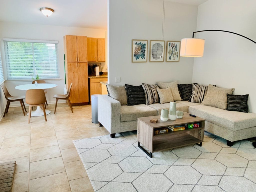 Spacious living area with cozy sectional, modern dining set, and a bright kitchen. Ideal for short stays | Dream TDY