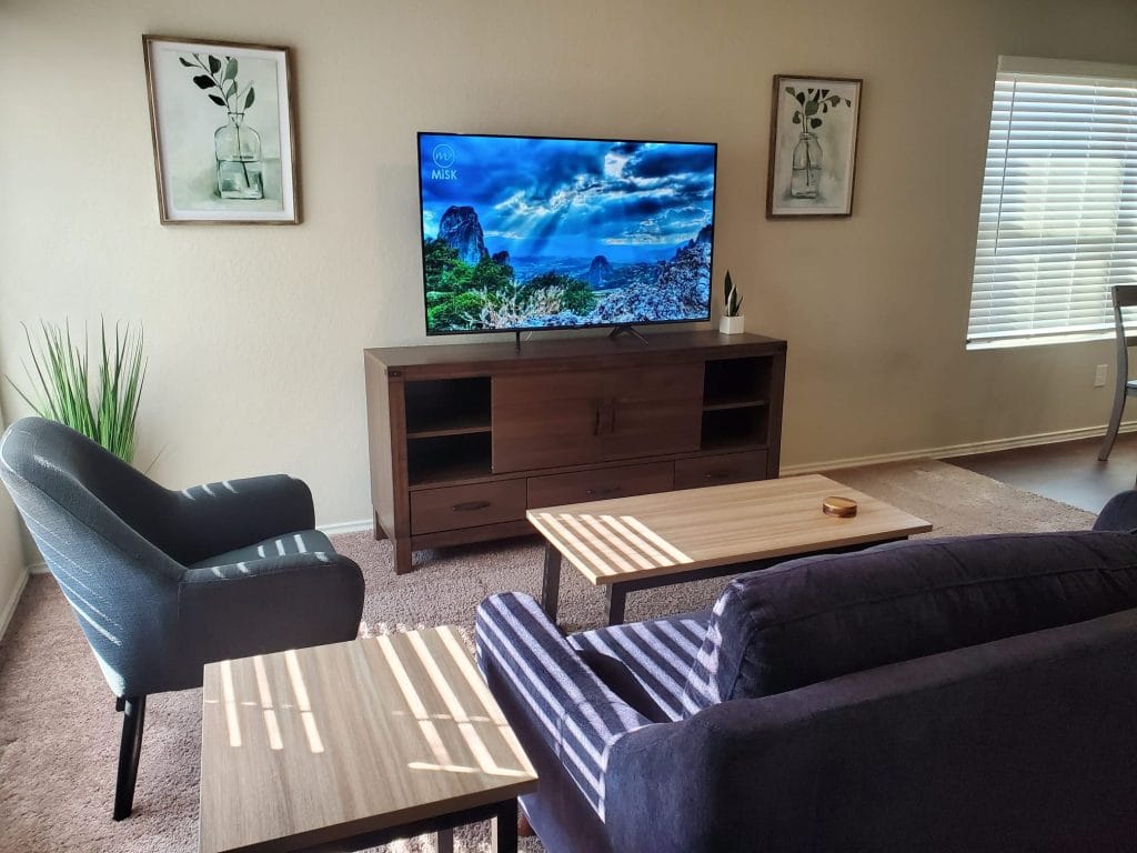 Spacious living area with modern décor, plush seating, and a large TV. Ideal for relaxation or remote work| Dream TDY