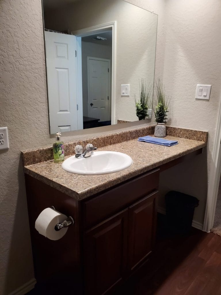 Stylish bathroom with granite countertop, modern fixtures, and ample storage. Bright and inviting for a refreshing stay | Dream TDY