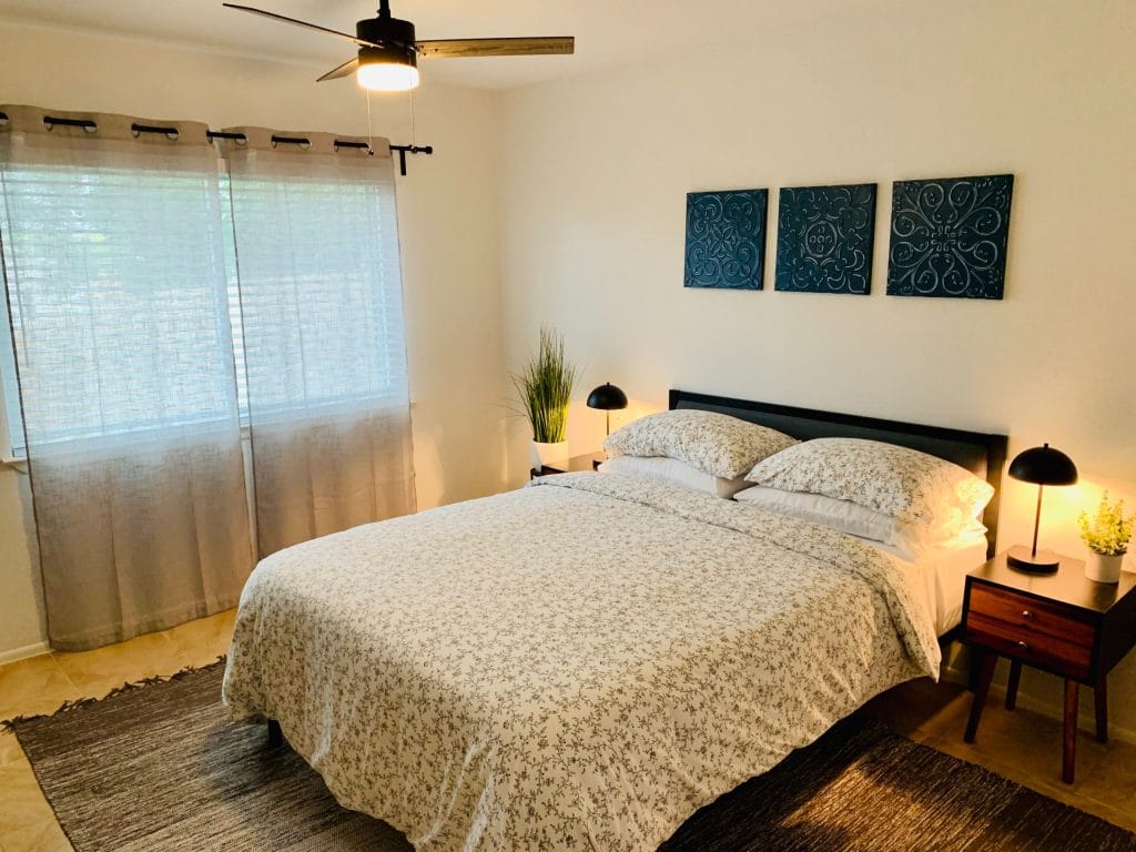 Bright, cozy bedroom with a comfortable bed, modern decor, and ample natural light. Features stylish nightstands and clean ambiance | Dream TDY