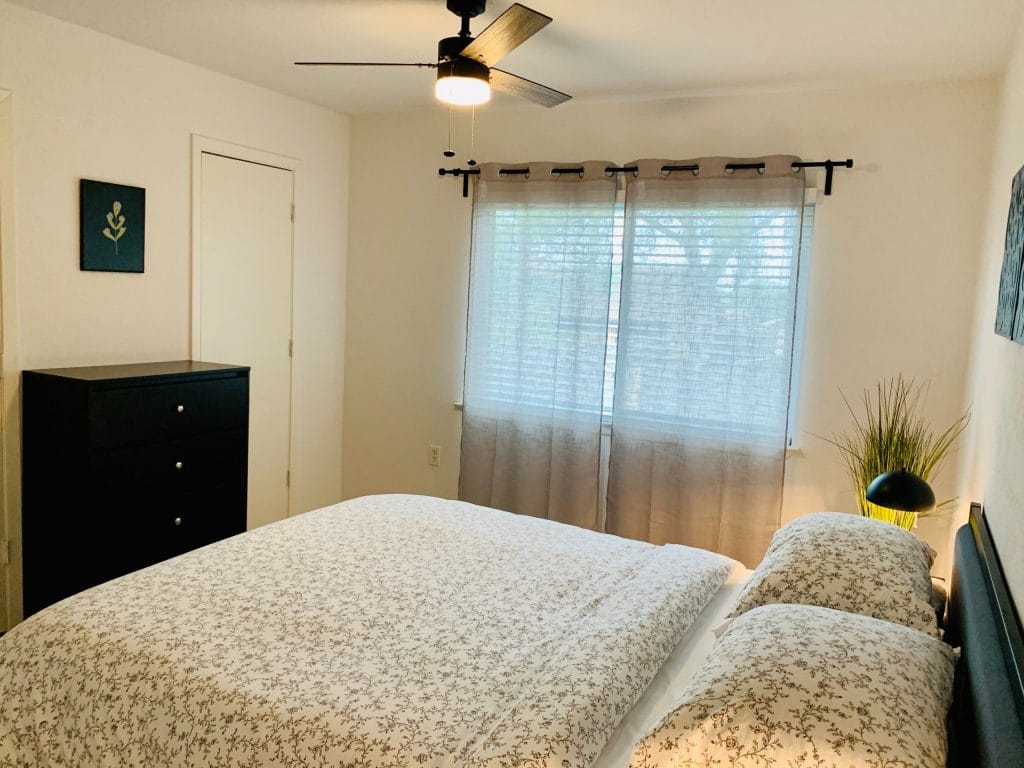 Cozy, well-lit bedroom with a modern touch, featuring a stylish bed, dresser, and ample natural light | Dream TDY