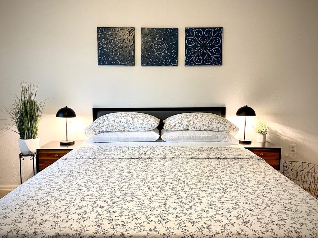 Cozy bedroom featuring elegant floral bedding, modern lamps, and a relaxing ambiance; perfect for unwinding | Dream TDY