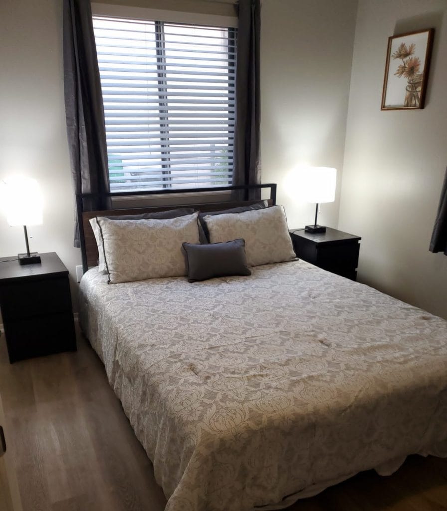 Cozy bedroom with modern decor, ample natural light, and clean linens; perfect for a restful stay | Dream TDY