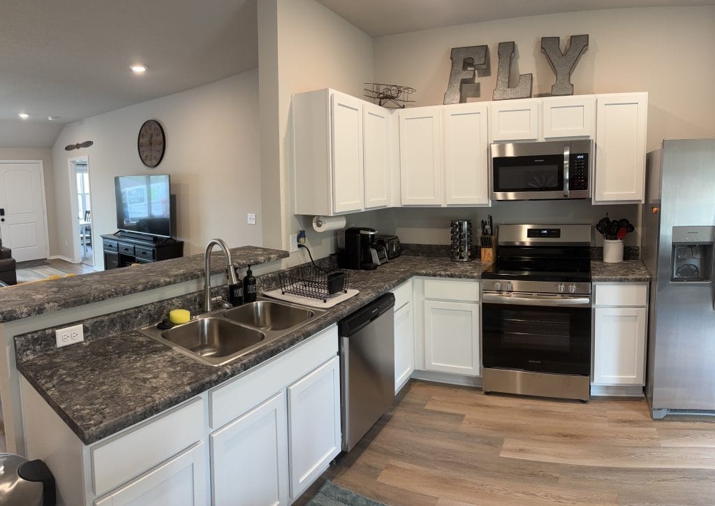 Modern kitchen with stainless appliances, granite countertops, and a cozy dining area; ideal for meal prep and relaxation.