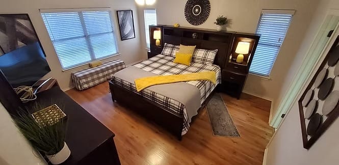 Cozy bedroom features a plush queen bed, modern furnishings, bright windows, and a dedicated workspace | Dream TDY