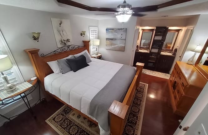 Elegant bedroom with cozy king bed, hardwood floors, and modern ensuite bath. Perfect for relaxation and productivity | Dream TDY