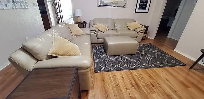 Cozy living area featuring plush leather seating, a decorative rug, and modern decor—ideal for relaxation. | Dream TDY