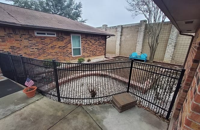 Charming outdoor space with serene landscaping, perfect for relaxation. Enjoy privacy in a fenced area with seating options | Dream TDY