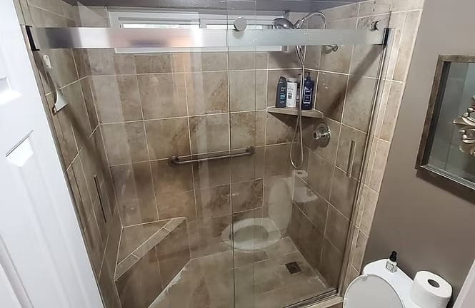 Stylish glass shower with modern tiles, well-lit space, and convenient grab bars ensuring safety and comfort | Dream TDY