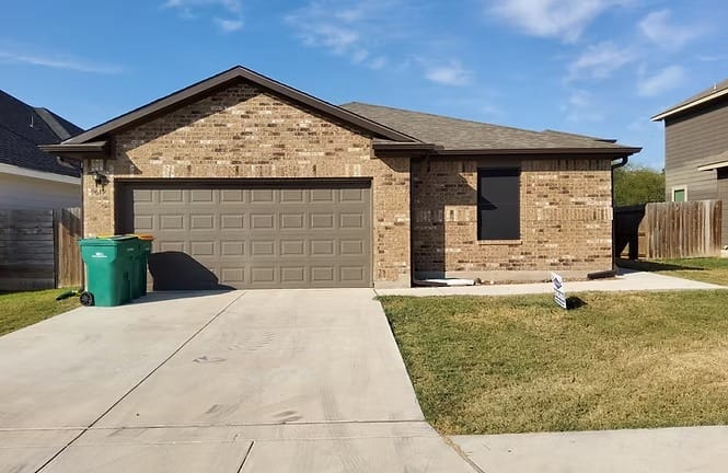 Stylish brick exterior with a spacious driveway and well-kept yard, perfect for relaxing in your home away from home | Dream TDY