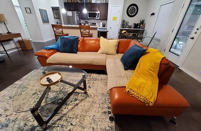 Stylish living area featuring a cozy sectional sofa, modern decor, and a glass coffee table. Enjoy the open layout and natural light | Dream TDY