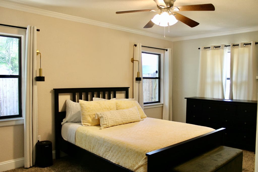 Cozy bedroom with a stylish black bed, spacious layout, ample natural light, and modern furniture | Dream TDY