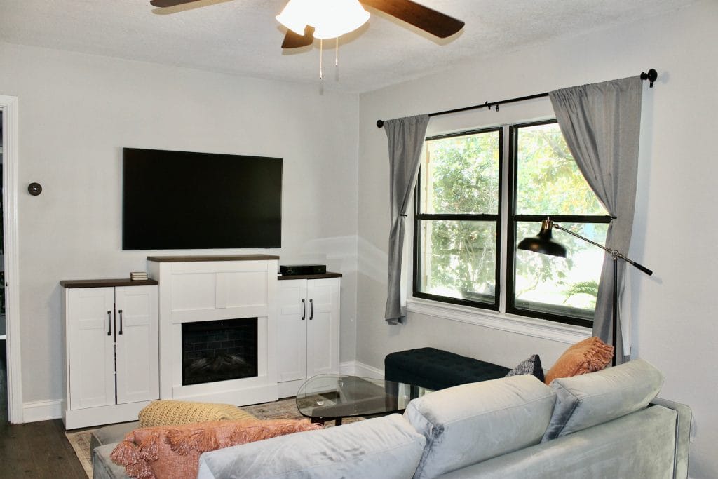 Stylish living area with modern furniture, a large TV, cozy ambiance, and ample natural light for relaxation or work | Dream TDY