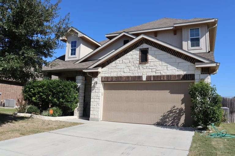 Charming exterior with modern stone accents. Spacious driveway, well-maintained landscaping, and a serene outdoor vibe | Dream TDY