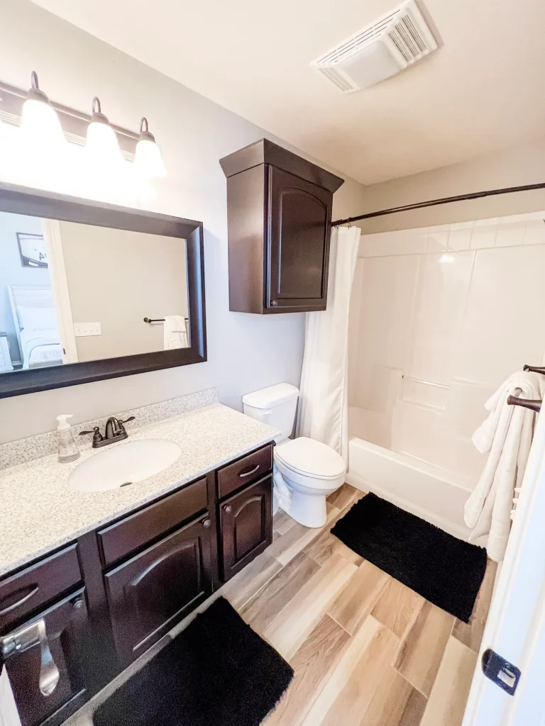 Stylish bathroom with sleek granite countertops, modern fixtures, and plush rugs for added comfort | Dream TDY