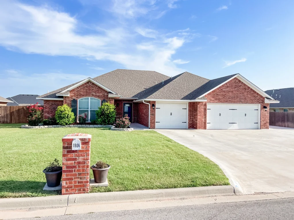 Charming brick exterior with manicured lawn, two-car garage, and inviting entry. Perfect for a relaxing stay | Dream TDY