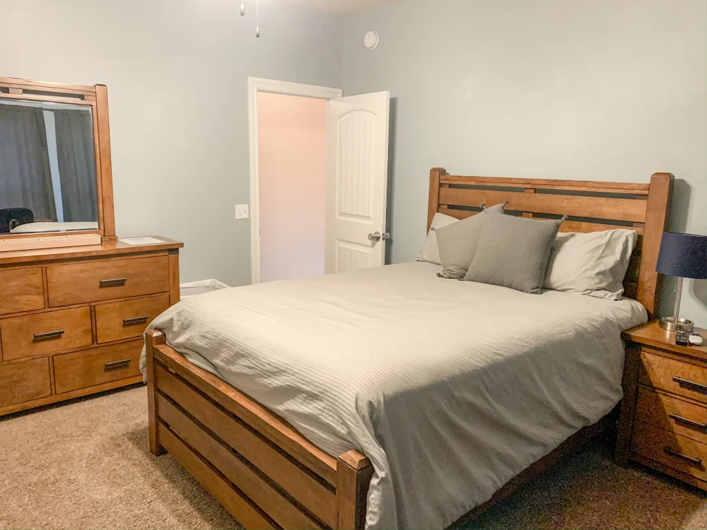 Cozy bedroom with a wooden bed, elegant dresser, and ample natural light | Dream TDY