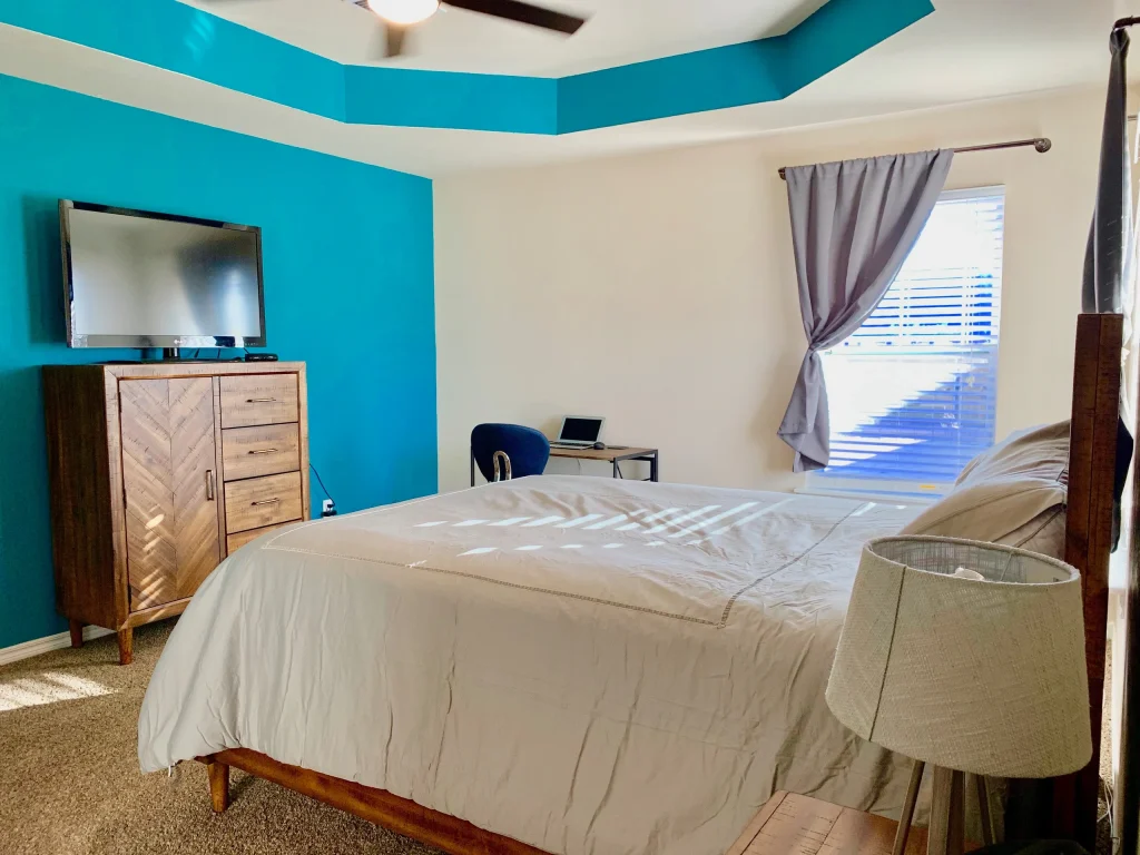 Stylish bedroom with modern furnishings, TV, dedicated workspace, and ample natural light | Dream TDY